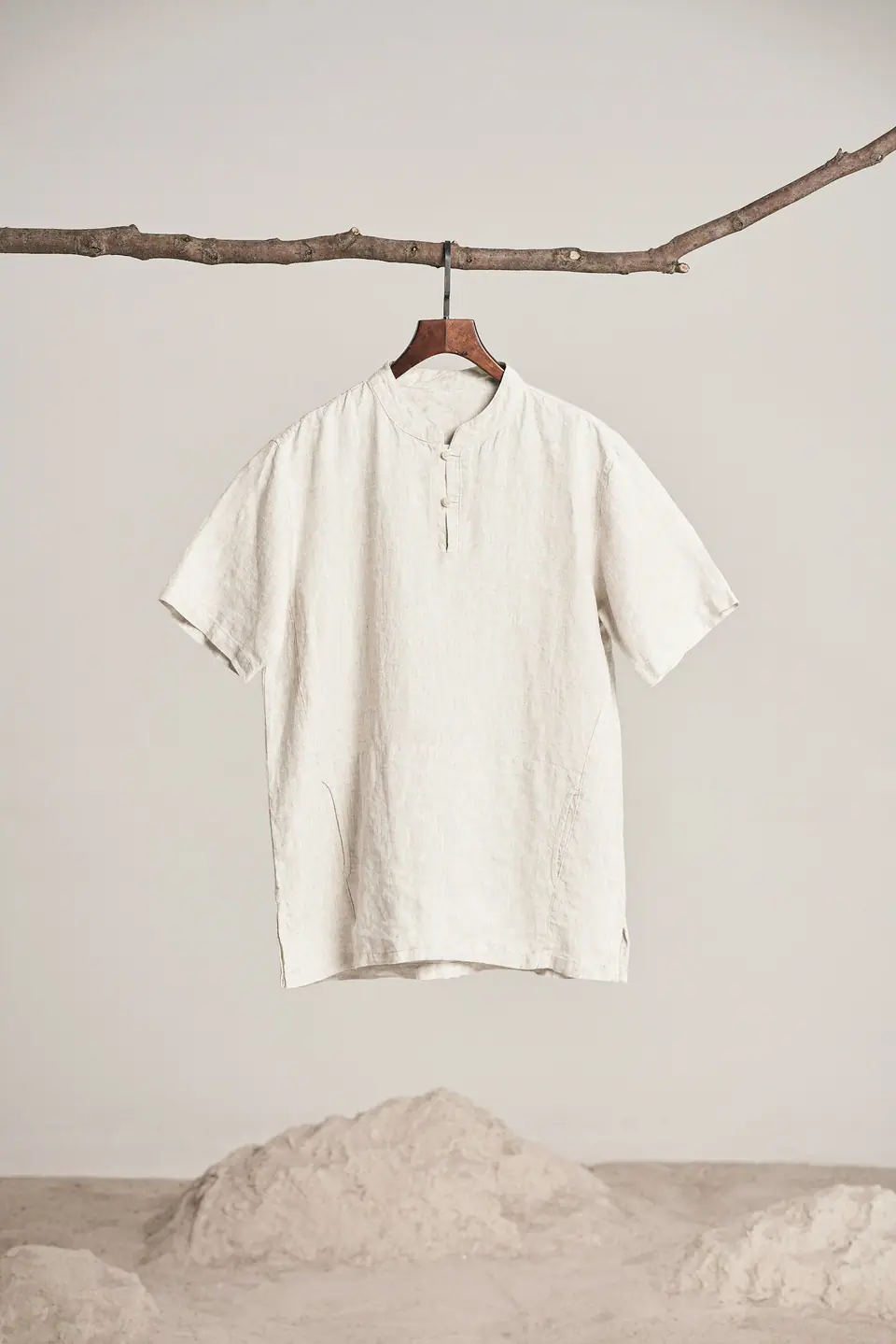 Camisa de lino beige de manga corta colgada sobre fondo claro