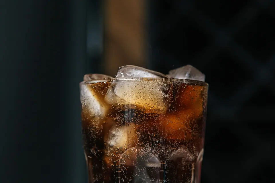 Vaso de gaseosa con hielo y burbujas